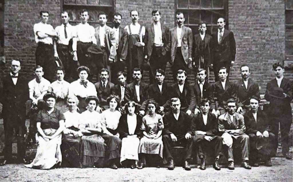Group portrait of 26 BMC employees, including many immigrant men and women.