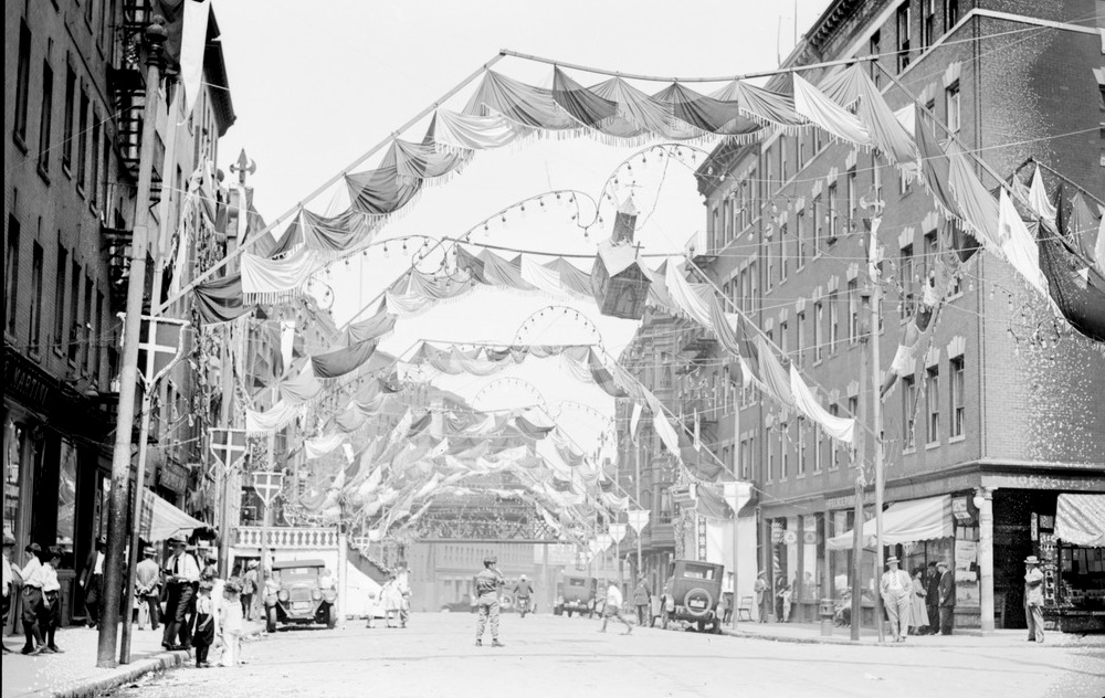 A photograph of Hanover Street with various decorations in the air spanning the length of the street, including decorative lights, crests, and scarves.